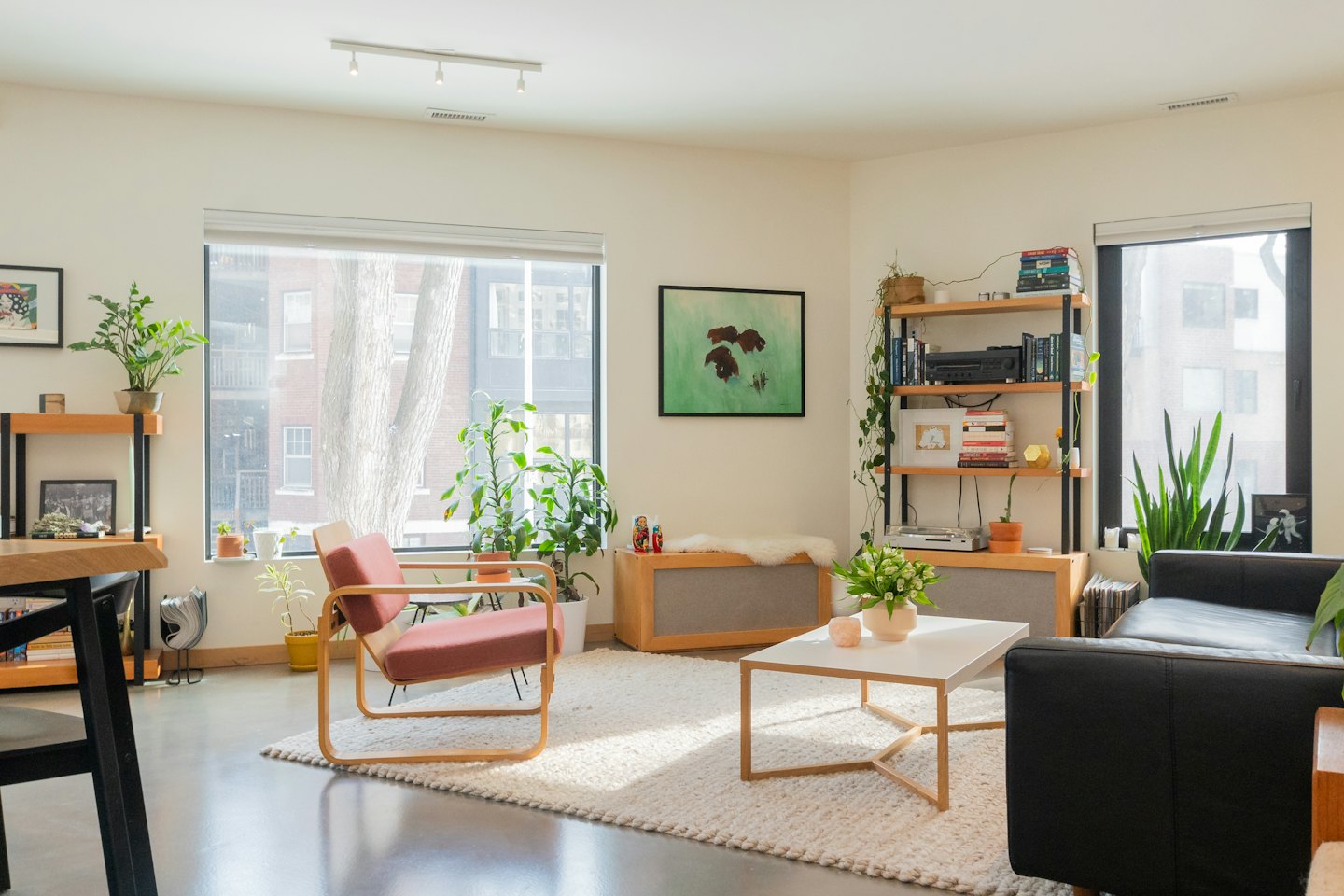 Modern living room with red armchair and plants.