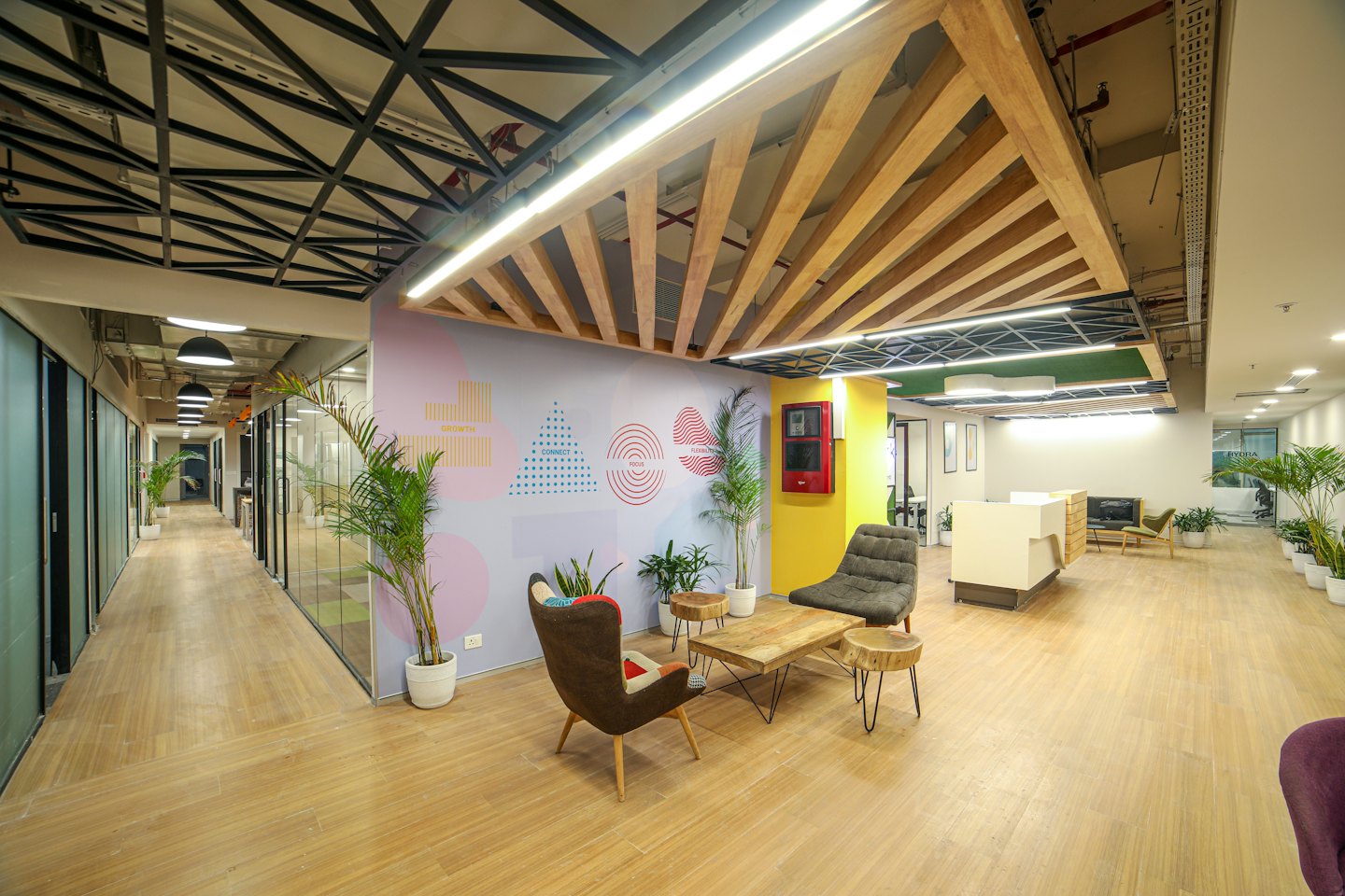 Modern office lounge with a hallway of glass offices.